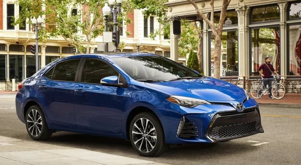 A blue 2019 Toyota Corolla is shown parked near a store.